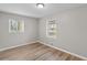 Comfortable bedroom featuring bright windows, neutral walls, and durable wood-look flooring at 7323 Howard Pl, Jonesboro, GA 30236