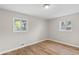 Sunny bedroom showcasing bright windows, neutral walls, and wood-look flooring at 7323 Howard Pl, Jonesboro, GA 30236