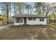 Charming white brick home featuring a cozy front yard and black shutters at 7323 Howard Pl, Jonesboro, GA 30236
