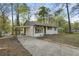 Side view of a white brick home, featuring a carport and long driveway at 7323 Howard Pl, Jonesboro, GA 30236