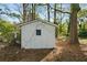 Outdoor storage shed nestled among trees in a partially wooded backyard at 7323 Howard Pl, Jonesboro, GA 30236