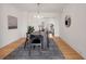 This dining room features modern lighting, decor, and a large rug below the long wooden table and black chairs at 1325 Peachtree Ne St # 402, Atlanta, GA 30309