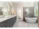 Contemporary bathroom with dual vanity, marble shower and soaking tub at 34 Greenland Trce, Atlanta, GA 30342