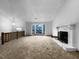 This large living room features neutral carpet, a fireplace, and large windows at 4933 Bayside Ct, Stone Mountain, GA 30088
