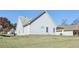 An exterior backyard showing a sloped lawn of a home with light blue siding and a roof with light gray shingles at 1128 Strath Clyde Way, Mcdonough, GA 30253