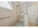 Bright bathroom featuring a tiled shower with bench and window allowing natural light at 1128 Strath Clyde Way, Mcdonough, GA 30253