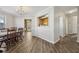 Dining area with a modern chandelier, adjacent to the kitchen, featuring laminate flooring and neutral paint at 1128 Strath Clyde Way, Mcdonough, GA 30253