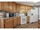 Cozy kitchen features wood cabinets, laminate countertops, and modern white appliances at 1128 Strath Clyde Way, Mcdonough, GA 30253