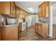 Efficient kitchen layout with wood cabinets, white appliances, laminate flooring, and plenty of counter space at 1128 Strath Clyde Way, Mcdonough, GA 30253