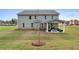 Large backyard featuring a covered patio with outdoor seating area and a fire pit at 111 Felicity Pike, Locust Grove, GA 30248