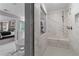 Modern glass shower with marble-look tiling and a soaking tub viewable through the open bathroom entrance at 111 Felicity Pike, Locust Grove, GA 30248
