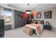 Modern bedroom featuring sport themed decor, tray ceiling, a large window, and dark gray walls at 111 Felicity Pike, Locust Grove, GA 30248