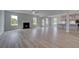 Open-concept living room with hardwood floors, fireplace, and lots of natural light at 111 Felicity Pike, Locust Grove, GA 30248