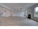 Open living room with light hardwood floors, fan, fireplace, and bright natural light at 111 Felicity Pike, Locust Grove, GA 30248