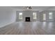 Bright living room featuring a cozy fireplace, light-colored hardwood floors, and large windows at 111 Felicity Pike, Locust Grove, GA 30248