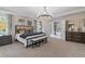Elegant main bedroom features a chandelier, tray ceiling, a king bed, and ensuite bathroom access at 111 Felicity Pike, Locust Grove, GA 30248