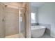 Modern bathroom featuring a glass-enclosed shower and a separate soaking tub near a bright window at 193 Haverling Pass, Hampton, GA 30228