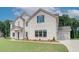 Side view of a two-story white brick home, showcasing the attached two-car garage and manicured lawn at 193 Haverling Pass, Hampton, GA 30228