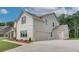Attached three-car garage with concrete driveway and the side and rear of the white brick home at 193 Haverling Pass, Hampton, GA 30228