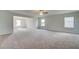 Spacious living room with plush carpeting, multiple windows for ample natural light, and ceiling fan at 193 Haverling Pass, Hampton, GA 30228