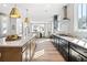 Bright open kitchen with stainless appliances and large island that flows into the dining area at 5120 Token Chase, Cumming, GA 30040