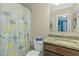 Well-lit bathroom featuring a granite countertop, stylish vanity, and a patterned shower curtain at 205 Bergen Dr, Fayetteville, GA 30215