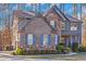 Charming two-story home with stone accents, blue shutters, and lush landscaping at 205 Bergen Dr, Fayetteville, GA 30215