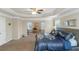 Spacious main bedroom features a tray ceiling, ceiling fan, sitting area and decorative bedding at 205 Bergen Dr, Fayetteville, GA 30215