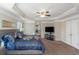 Bright main bedroom features a ceiling fan, neutral paint, carpet and large television at 205 Bergen Dr, Fayetteville, GA 30215