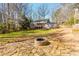 Spacious backyard featuring mature trees and fire pit area with stone patio at 2733 Eagle Ridge Rd, Marietta, GA 30062