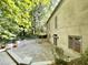 Backyard patio features a retaining wall and lush green hillside, offering privacy and natural beauty at 973 Peachtree Battle Ave, Atlanta, GA 30327