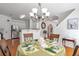 Dining room featuring a chandelier, hardwood floors, and seating for four at 3641 Devenwood Way, Buford, GA 30519