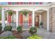 Close-up of the inviting front porch with hanging plants, red shutters, and a wooden front door at 3641 Devenwood Way, Buford, GA 30519