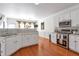 Bright kitchen with white cabinets, stainless steel appliances and hardwood floors at 3641 Devenwood Way, Buford, GA 30519