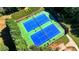 Aerial view of well-maintained tennis courts surrounded by trees and landscaping at 3641 Devenwood Way, Buford, GA 30519