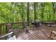 Spacious wooden deck with outdoor seating and grill surrounded by lush trees at 1291 Marcelle Heights Pl, Norcross, GA 30093