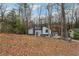 View of home with gray exterior on wooded lot with mature trees in the front yard at 1291 Marcelle Heights Pl, Norcross, GA 30093