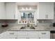 Well-lit kitchen showcasing granite countertops, stainless steel sink, and a window with backyard views at 1291 Marcelle Heights Pl, Norcross, GA 30093