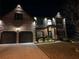 Stunning brick home with landscape lighting and a welcoming two-car garage at night at 2640 Paddock Point Pl, Dacula, GA 30019