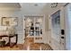 Bright foyer featuring wood floors, an office with French doors, and natural light streaming in from the front door at 2640 Paddock Point Pl, Dacula, GA 30019