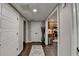 Hallway with dark wood flooring leading to kitchen and featuring white paneled doors at 2640 Paddock Point Pl, Dacula, GA 30019
