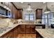 Modern kitchen featuring granite countertops, stainless steel appliances, and dark wood cabinetry at 2640 Paddock Point Pl, Dacula, GA 30019