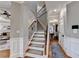 Elegant staircase with wrought iron railings and carpeted steps connecting multiple floors of the home at 2640 Paddock Point Pl, Dacula, GA 30019