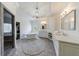 Luxurious bathroom features soaking tub, chandelier, dual sink vanity, and a glass-enclosed shower at 350 Newcastle Dr, Alpharetta, GA 30009