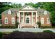 Stately brick home with grand entrance featuring white columns and manicured landscaping at 350 Newcastle Dr, Alpharetta, GA 30009