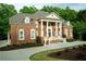Stately brick home with manicured landscaping and elegant front entrance at 350 Newcastle Dr, Alpharetta, GA 30009
