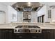 Gourmet kitchen featuring a Viking cooktop, stainless steel hood, stone fireplace, and hardwood floors at 350 Newcastle Dr, Alpharetta, GA 30009