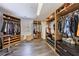 Custom walk-in closet with wood shelving, drawers, and ample storage space for clothes and shoes at 350 Newcastle Dr, Alpharetta, GA 30009