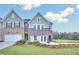 Charming two-story home features a modern gray brick facade, well-manicured lawn, and a two car garage at 5765 Tillman Way, Powder Springs, GA 30127