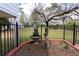 This backyard features a black iron fence, flowering tree, fountain and meticulously manicured landscaping at 1316 Milstead Ave, Conyers, GA 30012